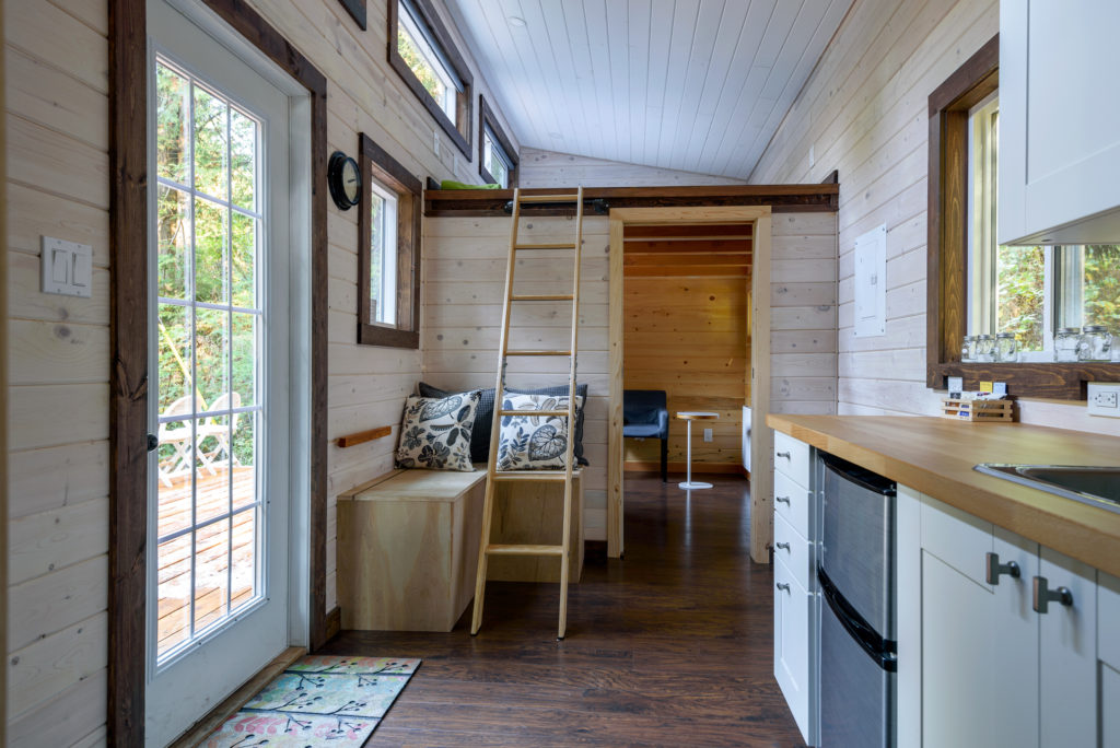 Bright and cozy tiny house interior showcasing smart storage and layout — an example of tiny house living lessons.