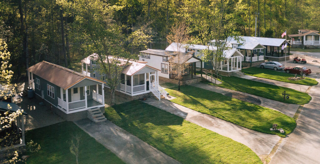 Aerial view of tiny home community with green lawns and trees