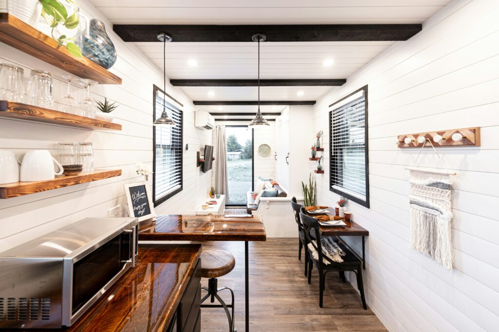 Bright and modern tiny home kitchen and dining area – tiny house news feature