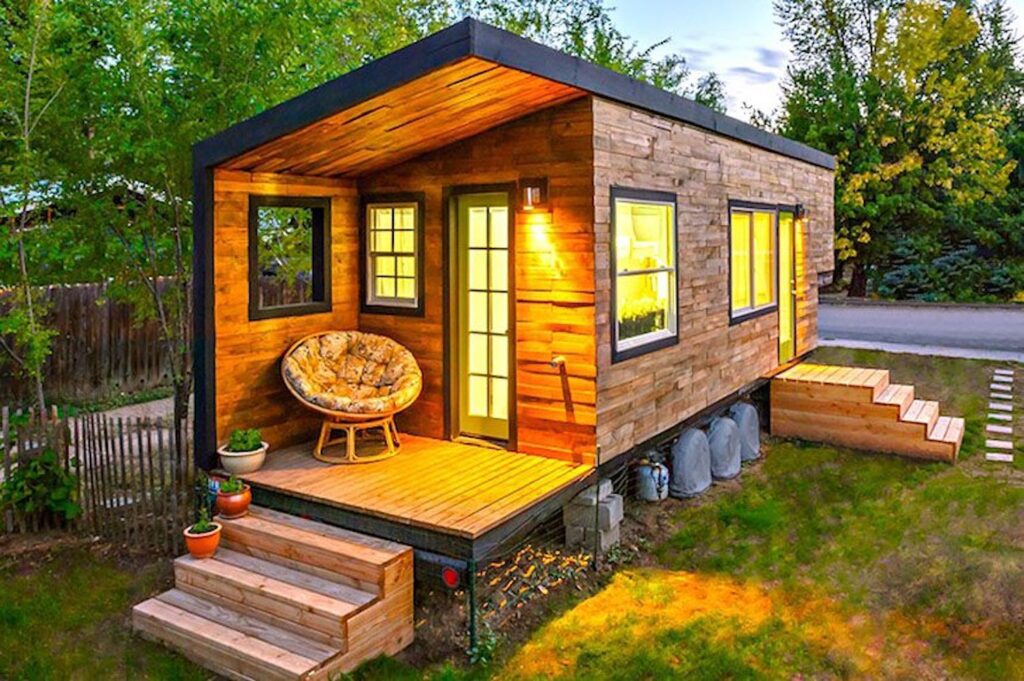 Modern wooden tiny home with porch at sunset