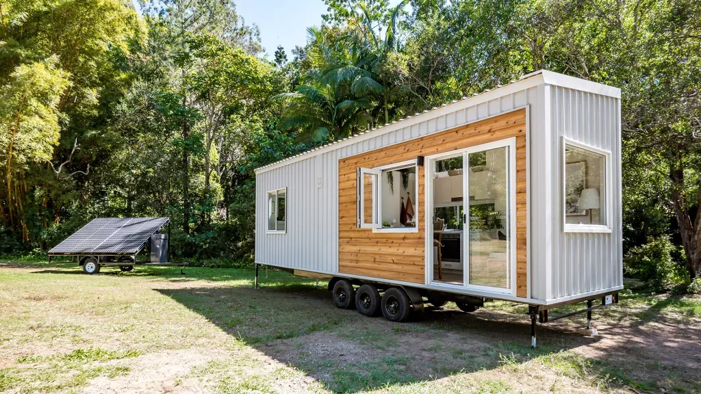 Eco friendly tiny house on wheels with solar panel trailer in forest