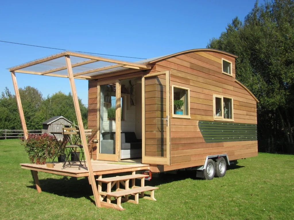 Rustic Tiny Home with Porch – Built by a Tiny Home Builder Rustic mobile tiny home with wood siding and outdoor porch, designed by a top tiny home builder.